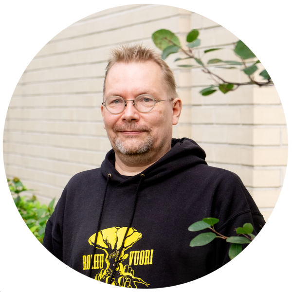 Rantanen katsoo hymyillen kameraan. Taustalla vaalea seinä ja kaupunkiluontoa.