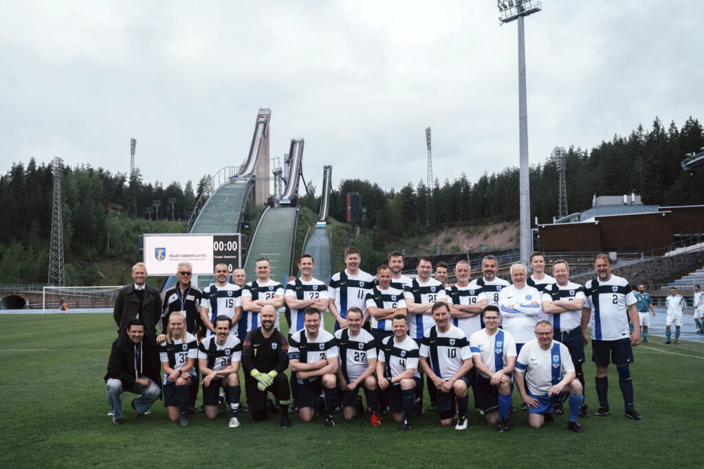 Ryhmäkuva joukkueesta, taustalla Lahden hyppyrimäki.